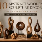 A collection of various abstract wooden sculptures in warm tones arranged on a wooden table against a neutral wall. The sculptures feature organic shapes, loops, rings, a teardrop, and stacked stones, showcasing smooth finishes and rich wood grains. Text at the top reads: "10 ABSTRACT WOODEN SCULPTURE DECOR TO ELEVATE ANY ROOM" and "CURATED FOR MODERN INTERIORS." Perfect inspiration for modern home decor and minimalist interior design.