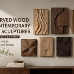 A collection of seven contemporary carved wood relief sculptures displayed on a neutral wall above a wooden console table. The artwork features diverse geometric, wavy, and textured abstract designs in varying shades of light and dark natural wood. Text on the left reads, "7 CARVED WOOD CONTEMPORARY RELIEF SCULPTURES WORTH COLLECTING. Elevate Your Walls With Depth and Drama." Styling details include a small potted plant, a wooden bowl, and art books on the console.