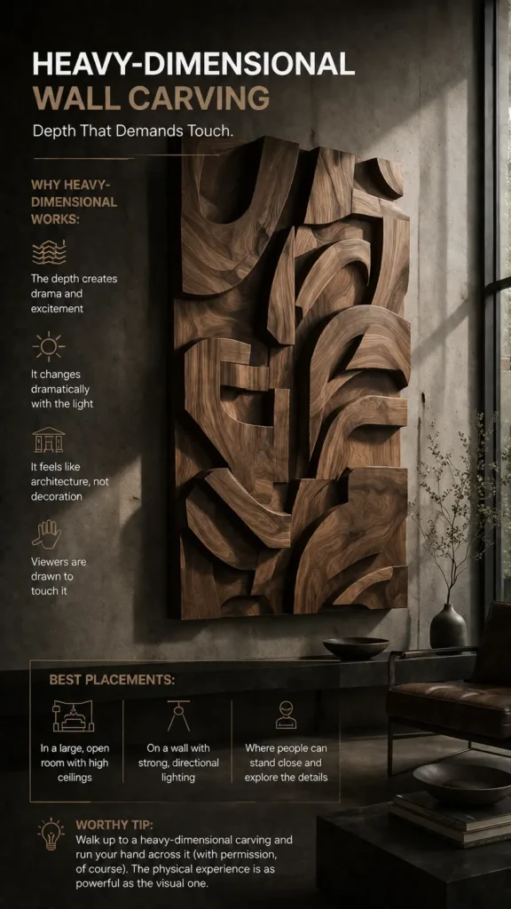 An infographic titled "Heavy-Dimensional Wall Carving." A massive, high-relief wood wall sculpture with thick, flowing, abstract carved wooden curves is mounted on a concrete wall. Text on the left covers "Why Heavy-Dimensional Works" (drama, light changes, architectural feel, tactile draw) and "Best Placements" (large rooms, strong directional lighting, close proximity). A "Worthy Tip" encourages viewers to experience the artwork's power by touching the texture.
