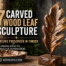 Pinterest graphic titled "7 CARVED WOOD LEAF SCULPTURE: NATURE PRESERVED IN TIMBER - STUNNING IDEAS TO BRING THE OUTDOORS IN." The image displays a detailed wooden leaf sculpture mounted on a metal stem and solid block base on a rustic wooden table. To the left is a carved bowl with decorative spheres, and to the right sits a potted green plant against a dark, warm background. The bottom left features the website logo WOODZAA.COM.